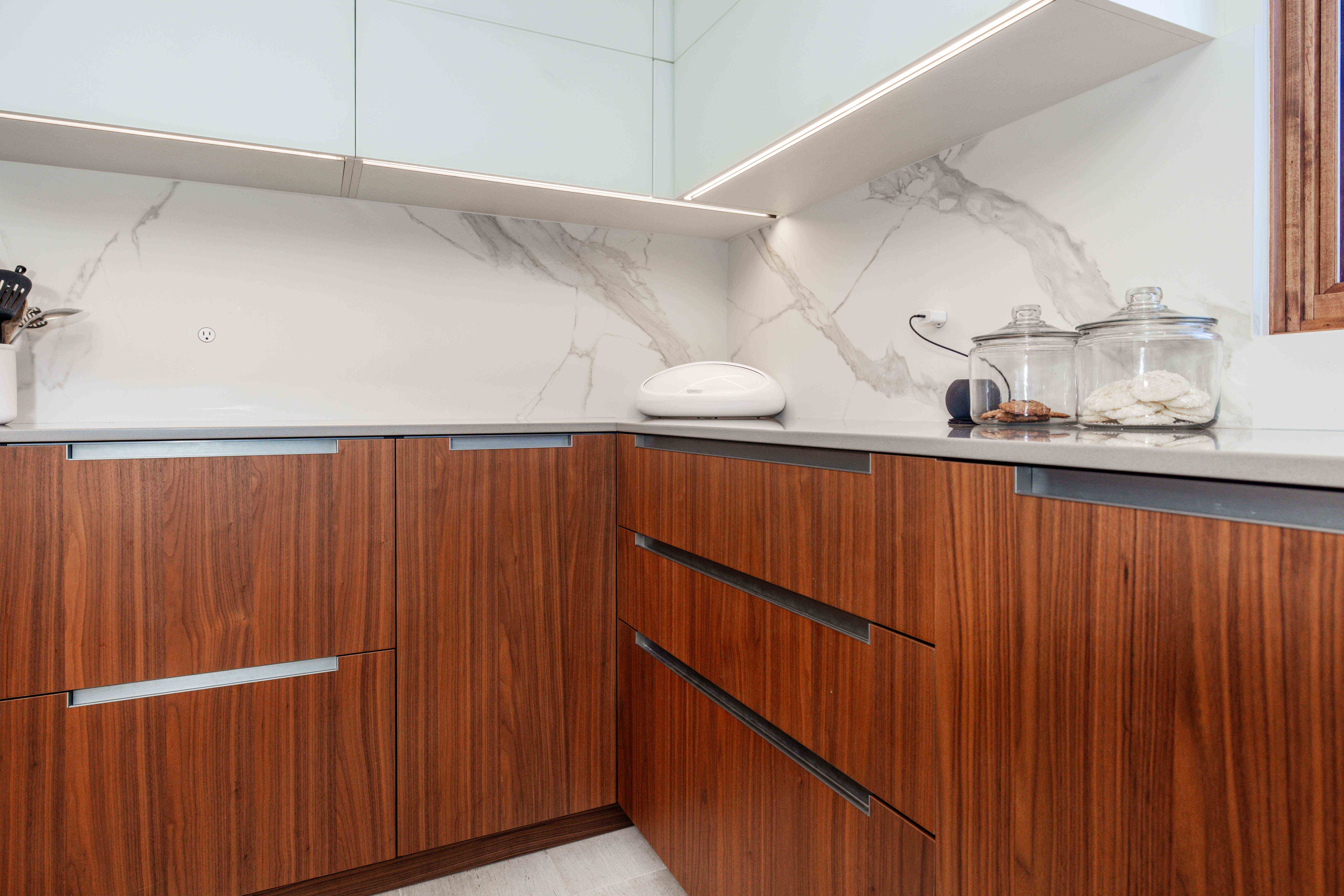 modern U-shaped kitchen with an island american walnut wood cabinets custom kitchen renovation design and integrated applicances